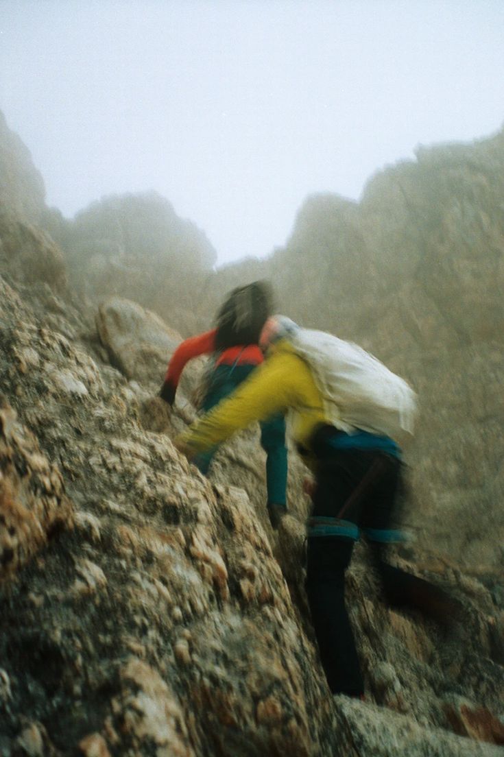 Hiker climbing a rocky mountain trail in the mist