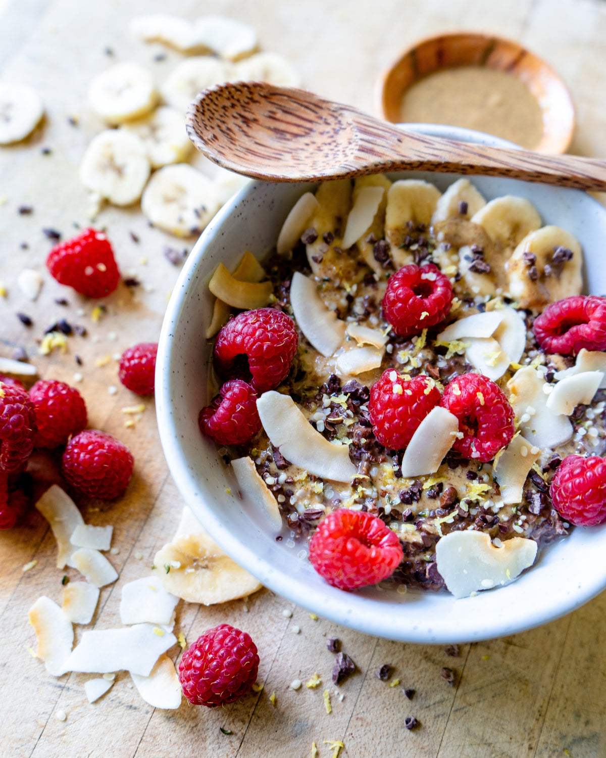 Cacao quinoa porridge topped with raspberries, banana and coconut