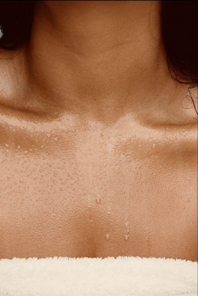 Close-up of a person's neck with visible skin texture and a white towel underneath.

