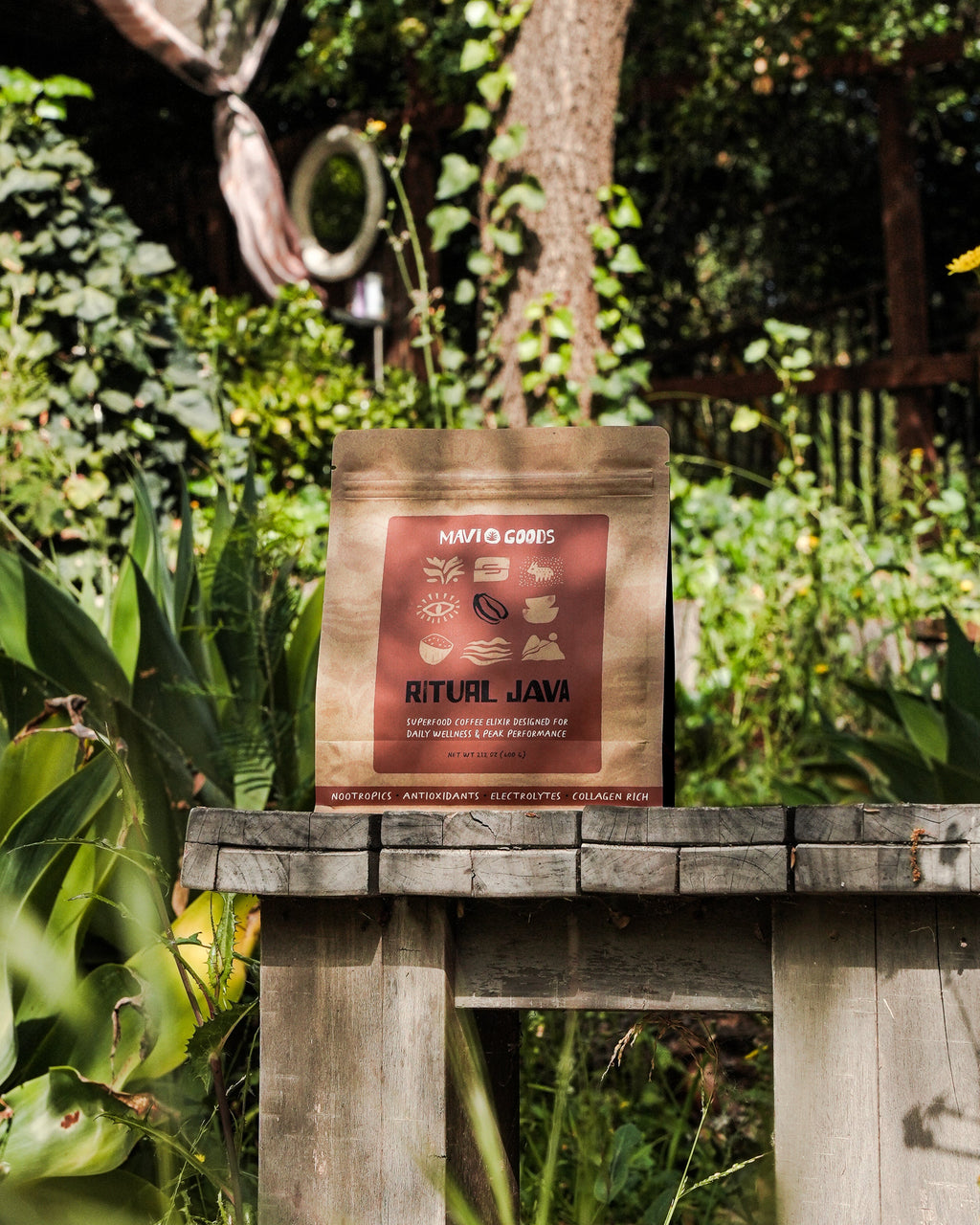 Bag of coffee on a wooden table in a garden setting

