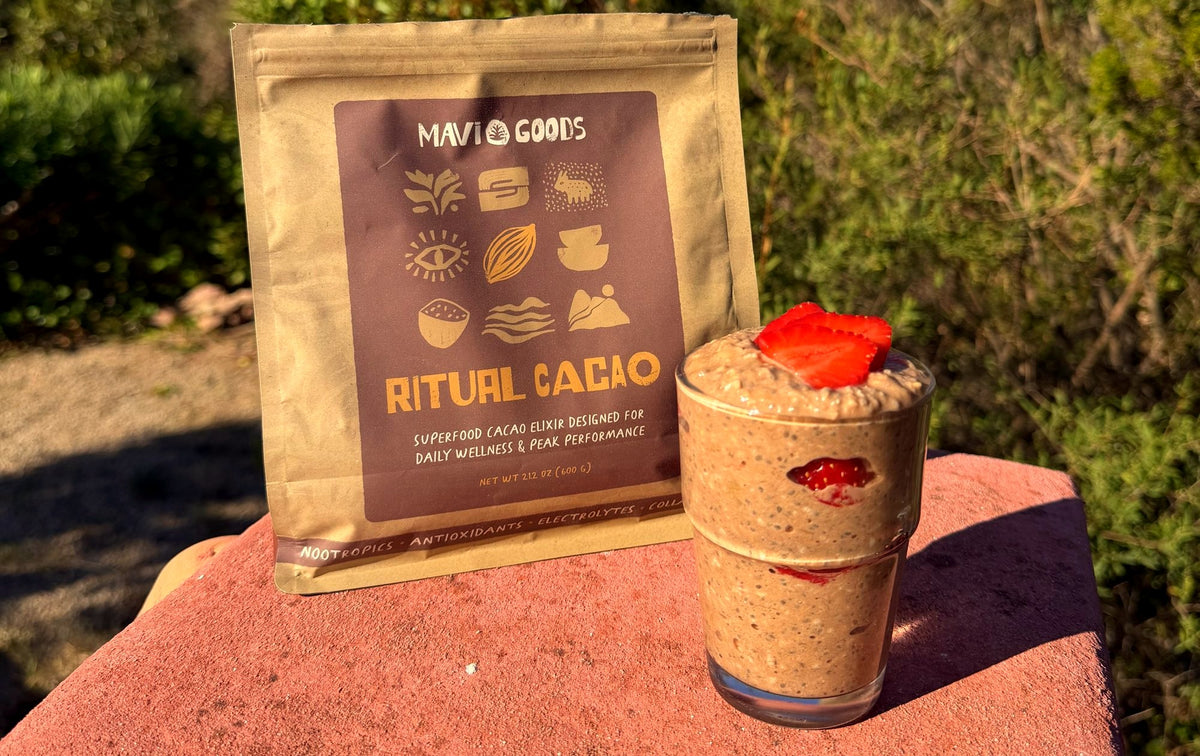 Glass of All-Day Energy Oatmeal with strawberries beside Ritual Cacao outdoors